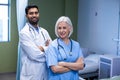 Doctor and nurse standing with arms crossed in hospital