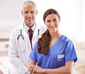 Doctor, nurse and together in portrait with arms crossed, medical support and wellness in hospital. Medic, mature man Royalty Free Stock Photo