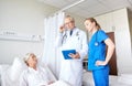 Doctor and nurse visiting senior woman at hospital Royalty Free Stock Photo