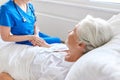 Doctor or nurse visiting senior woman at hospital Royalty Free Stock Photo