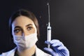 Doctor or nurse woman holds injection syringe and vaccine and squirting it Royalty Free Stock Photo