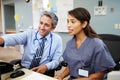 Doctor With Nurse Working At Nurses Station