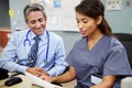 Doctor With Nurse Working At Nurses Station Royalty Free Stock Photo