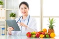 Doctor nutritionist using digital tablet with fruits and vegetable