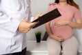 Doctor obstetrician gynecologist writes down complaints about the health of a pregnant girl in the third trimester. Polyhydramnios
