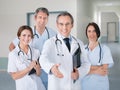 Doctor offering handshake while standing with team in hospital Royalty Free Stock Photo