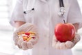 Doctor offering pills and apple to choose Royalty Free Stock Photo