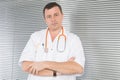 doctor in office arms cross with orange stethoscope Royalty Free Stock Photo