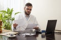 Doctor in the office sitting at a desk and reading medical records Royalty Free Stock Photo