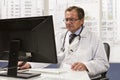 Doctor in office using computer, horizontal