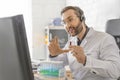 A doctor during an online consultation with a patient shows him a test tube with a blood sample.