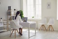 Doctor online. Female doctor works talking video call with patient using bast shoe while sitting at desk in back view Royalty Free Stock Photo