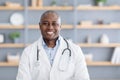 Doctor online, health care remotely. African american man in white coat with stethoscope in office interior in clinic