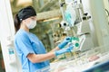 doctor operating equipment near newborn baby in incubator at neonatal resuscitation center