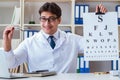 Doctor optician with letter chart conducting an eye test check Royalty Free Stock Photo