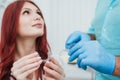 Doctor orthodontist shows a woman silicone aligners to straighten teeth