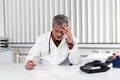 Doctor overstressed at his office desk