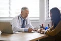 Doctor, paperwork and talking to a woman patient at hospital for a consultation or health insurance. A man listening to Royalty Free Stock Photo