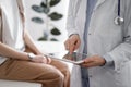 Doctor and patient in clinic. Friendly physician using tablet computer near a young woman. Medicine concept