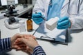 Doctor and patient in conversation about pill description, professional physician wearing white coat talking to mature woman Royalty Free Stock Photo