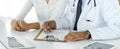 Doctor and patient discussing medical exam results while sitting at the desk in clinic, close-up. Male physician using Royalty Free Stock Photo