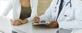 Doctor and patient discussing medical exam results while sitting at the desk in clinic, close-up. Male physician using Royalty Free Stock Photo