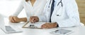 Doctor and patient discussing medical exam results while sitting at the desk in clinic, close-up. Male physician using Royalty Free Stock Photo