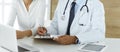 Doctor and patient discussing medical exam results while sitting at the desk in clinic, close-up. Male physician using Royalty Free Stock Photo