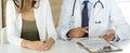 Doctor and patient discussing medical exam results while sitting at the desk in clinic, close-up. Male physician using Royalty Free Stock Photo