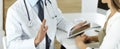 Doctor and patient discussing medical exam results while sitting at the desk in clinic, close-up. Male physician using Royalty Free Stock Photo