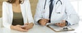 Doctor and patient discussing medical exam results while sitting at the desk in clinic, close-up. Male physician using Royalty Free Stock Photo