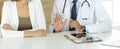 Doctor and patient discussing medical exam results while sitting at the desk in clinic, close-up. Male physician using Royalty Free Stock Photo