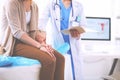 Doctor and patient discussing something while sitting at the table . Medicine and health care concept