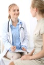 Doctor and patient having a pleasure talk while sitting at the chairs at hospital office. Healthcare and medicine