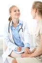 Doctor and patient having a pleasure talk while sitting at the chairs at hospital office. Healthcare and medicine