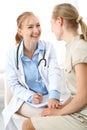 Doctor and patient having a pleasure talk while sitting at the chairs at hospital office. Healthcare and medicine