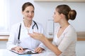 Doctor and patient having a pleasure talk while sitting at the desk at hospital office. Healthcare and medicine concept Royalty Free Stock Photo