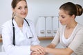 Doctor and patient having a pleasure talk while sitting at the desk at hospital office. Healthcare and medicine concept Royalty Free Stock Photo