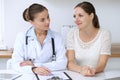 Doctor and patient having a pleasure talk while sitting at the desk at hospital office. Healthcare and medicine concept Royalty Free Stock Photo