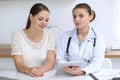 Doctor and patient having a pleasure talk while sitting at the desk at hospital office. Healthcare and medicine concept Royalty Free Stock Photo