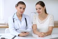 Doctor and patient having a pleasure talk while sitting at the desk at hospital office. Healthcare and medicine concept Royalty Free Stock Photo