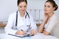 Doctor and patient having a pleasure talk while sitting at the desk at hospital office. Healthcare and medicine concept Royalty Free Stock Photo