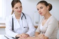 Doctor and patient having a pleasure talk while sitting at the desk at hospital office. Healthcare and medicine concept Royalty Free Stock Photo