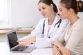 Doctor and patient having a pleasure talk while sitting at the desk at hospital office. Healthcare and medicine concept Royalty Free Stock Photo