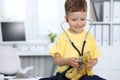 Doctor and patient in hospital. Happy little boy having fun while being examined with stethoscope. Healthcare and Royalty Free Stock Photo