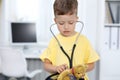 Doctor and patient in hospital. Happy little boy having fun while being examined with stethoscope. Healthcare and Royalty Free Stock Photo