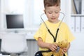 Doctor and patient in hospital. Happy little boy having fun while being examined with stethoscope. Healthcare and Royalty Free Stock Photo