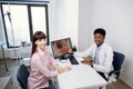 Afro-American man doctor, discussing the results of endoscopy with pretty Caucasian lady patient Royalty Free Stock Photo