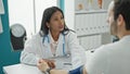 Doctor and patient sitting on table measuring pulse using tensiometer at the clinic