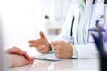 Doctor and patient talking while sitting at the desk in hospital office, close-up of human hands. Medicine and health Royalty Free Stock Photo